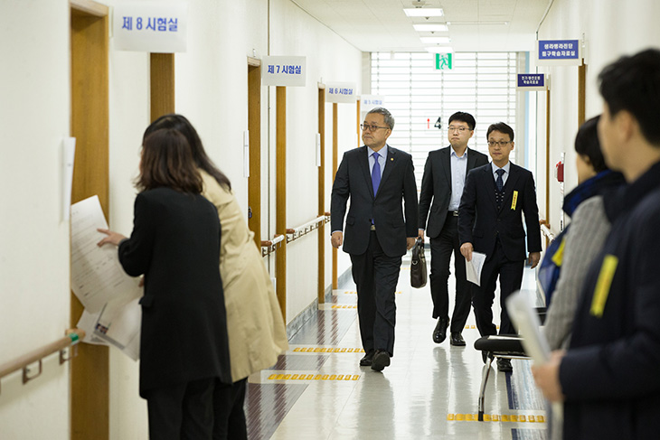 김판석 인사혁신처장이 2018 국가공무원 9급 공채 필기시험장을 방문하여 복도를 걸어가며 살펴보고 있는 모습