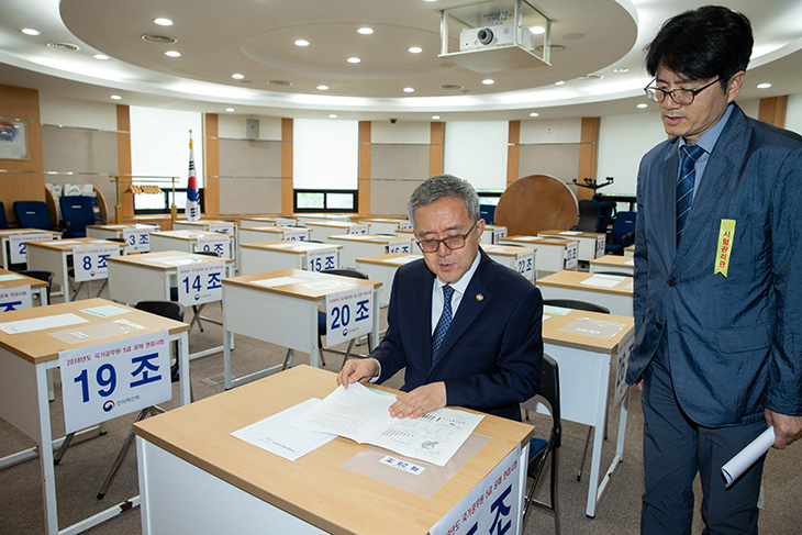 국가공무원인재개발원을 방문한 김판석 인사혁신처장이 시험 책상에 앉아  면접시험에 대해 살펴보고 있다