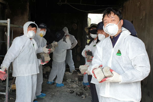 피해지역의 무너진 잔해물들을 치우는 공무원 봉사자들