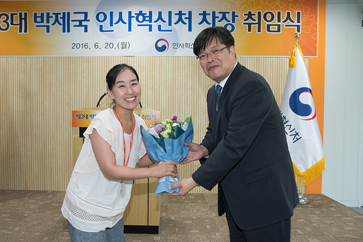 취임식장 단상 앞에서 축하 꽃다발을 건네 받으며 환영받는 박제국 인사혁신처 차장