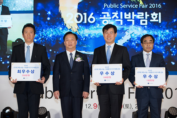 2016년 공무원 재능나눔·자원봉사 우수사례 공모전의 수상자들과 기념사진 촬영 중인 김동극 인사혁신처장.