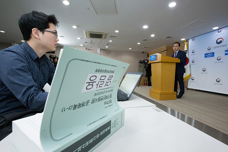 2017년도 정기재산변동사항 목록공개 책자가 펼쳐져 있고 기자들의 정만석 인사혁신처 윤리복무국장의 브리핑내용을 기자들이 노트북에 타자를 치고 있다