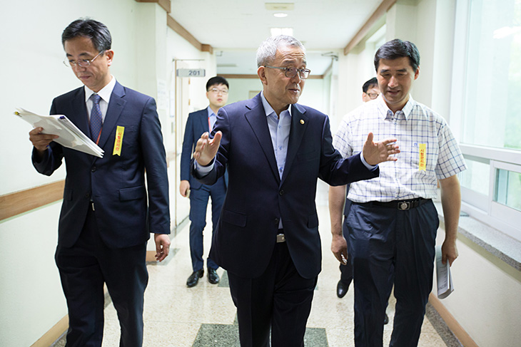 시험장 복도를 걸으며 관계자들과 이야기를 나누고 있는 김판석 인사혁신처장