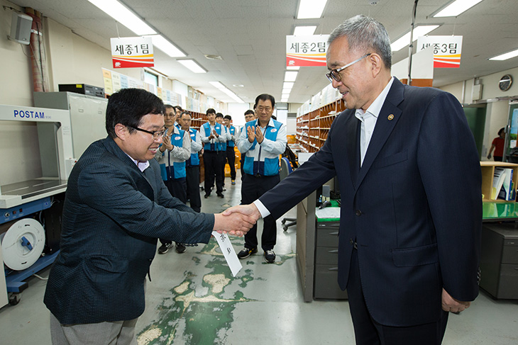 세종우체국의 집배원들을 격려하고 담당자와 악수를 나누고 있는 김판석 인사혁신처장