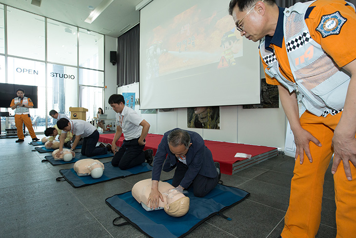 소방대원이 지켜보며 심폐소생술을 실습중인 인사혁신처 직원의 모습 