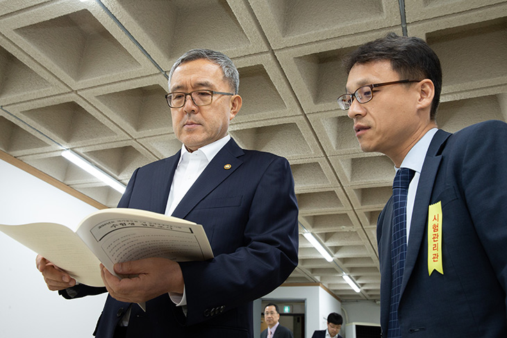 수험생 설문자료 문서를 살펴보는 김판석 인사혁신처장 