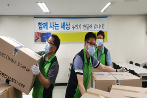 물품이 들어있는 박스를 나르는 봉사자들