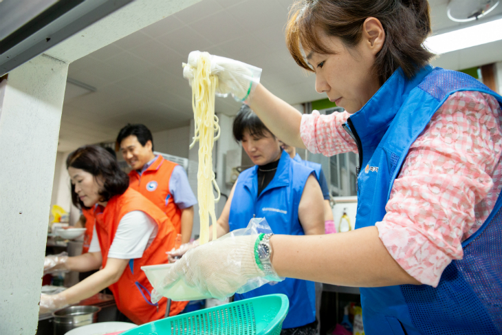 국수를 그릇에 담는 봉사자들