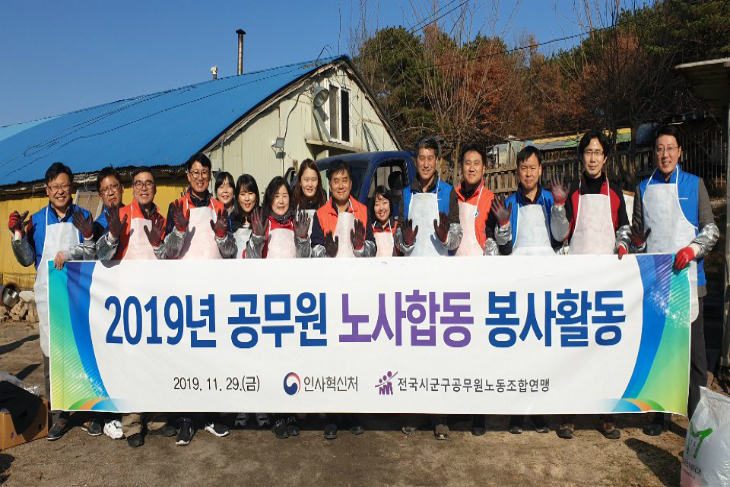 현수막을 들고 단체사진을 찍는 연탄배달 봉사자들