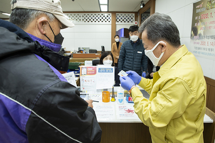 황서종 인사혁신처장이 공적마스크 판매를 돕기위해 구매자의 신분증을 확인하고 있는 모습