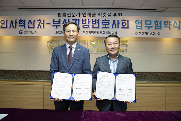 서명한 협약서를 펼쳐 들고 있는 이영갑 부산지방변호사회 회장과 황서종 인사혁신처장