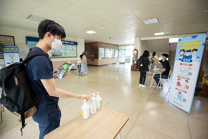 응시생들이 시험장에 입장하면서 손 소독과 발열 체크를 차례로 하는 모습