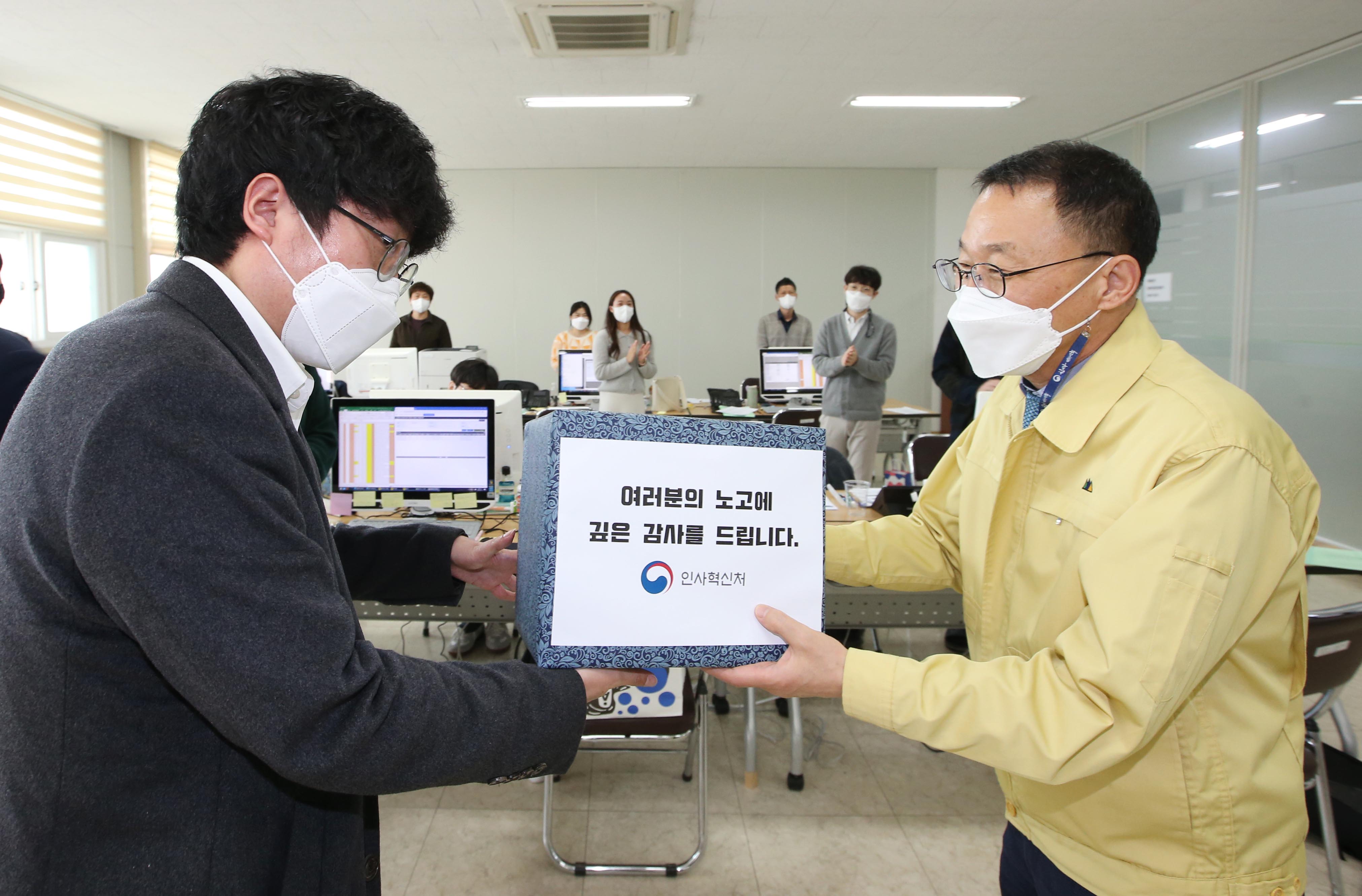 김우호 인사혁신처장이 15일 충북 청주시 흥덕보건소를 찾아 코로나19 확산에 따른 보건소 대응 지원을 위해 파견된 중앙부처 공무원에게 지원 물품을 전달하고 있는 모습